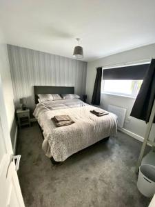 ein Schlafzimmer mit einem großen Bett und einem Fenster in der Unterkunft Bryn Mair cottage overlooking Snowdon in Caernarfon