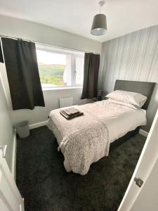 ein Schlafzimmer mit einem großen Bett und einem Fenster in der Unterkunft Bryn Mair cottage overlooking Snowdon in Caernarfon