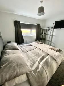 ein Schlafzimmer mit einem großen Bett vor einem Fenster in der Unterkunft Bryn Mair cottage overlooking Snowdon in Caernarfon