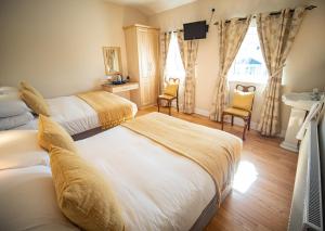 een hotelkamer met 2 bedden en een wastafel bij Ceol na Mara Guest House in Enniscrone