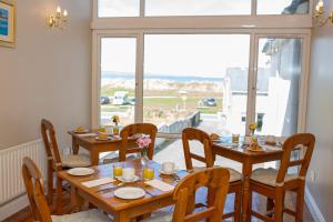 een eetkamer met een tafel en stoelen en een raam bij Ceol na Mara Guest House in Enniscrone