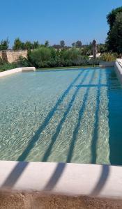 - une piscine d'eau bleue dans la cour dans l'établissement Torre Assunta Masseria, à Gallipoli