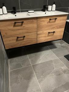 a bathroom with a wooden vanity with a sink at Apartmány Tobias in Běšiny