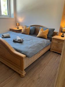 a large wooden bed in a room with two tables at Apartmány Tobias in Běšiny