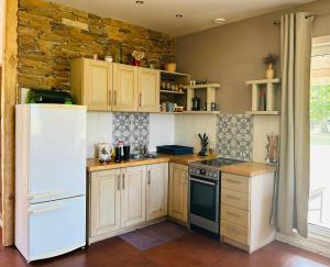 cocina con electrodomésticos blancos y pared de piedra en Mežalauki, en Kolka