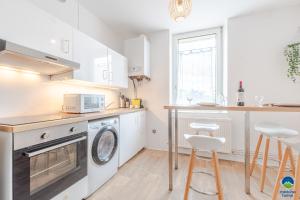 a white kitchen with a washer and dryer in it at matcha home Hettange in Hettange-Grande