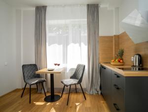 une cuisine avec une table et deux chaises ainsi qu'une fenêtre dans l'établissement Fort63 apartments, à Kaunas