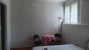 a table and chairs in a room with a brick wall at El Colmenar Habitaciones in Madrid