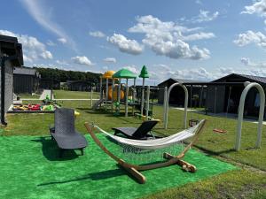 eine Hängematte und Stühle auf einem Spielplatz in der Unterkunft Silva in Rewal