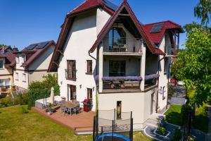 una grande casa bianca con balcone e cortile di All World in Gdynia a Gdynia