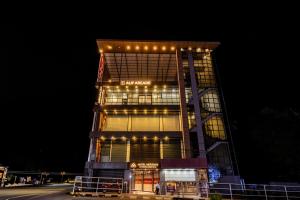 een hoog gebouw met 's nachts verlichting bij MERIDIAN BY Daan in Trivandrum