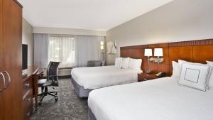 een hotelkamer met 2 bedden en een bureau bij Courtyard by Marriott Gulfport Beachfront in Gulfport