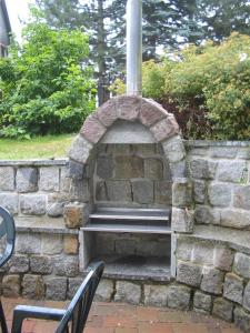 un mur en pierre avec un banc dans un parc dans l'établissement Ferienwohnung Gürth, à Kleinhennersdorf