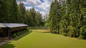 un grand jardin verdoyant avec un bâtiment et des arbres dans l'établissement Komáří Louka, à Nová Olešná