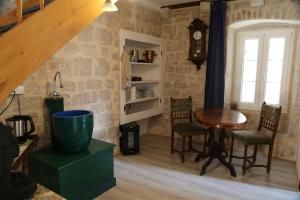 a room with a table and chairs and a clock at Golubica in Stari Grad