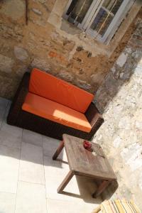 an orange couch sitting next to a wooden table at Golubica in Stari Grad