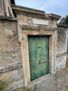 una puerta verde en el lateral de un edificio en Le Clos des Cadots - Chambre, en Chaintré