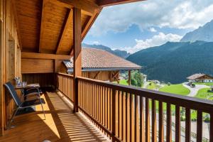 balkon ze stołem i widokiem na góry w obiekcie Villa Solinda App Puccini w mieście Selva di Val Gardena