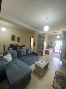 a living room with a blue couch and a table at Panoramic apartment in Shkodër