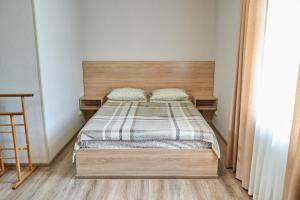 a bedroom with a bed with a wooden headboard at Каприз in Kamianets-Podilskyi