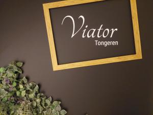 um sinal de quadro negro numa parede ao lado de uma planta em Viator Holidayhome em Tongeren