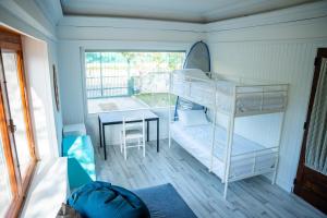 1 dormitorio con litera y mesa en Moby Dick Lodge Colares, en Colares