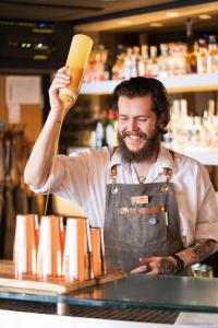 Un uomo in grembiule dietro un bancone di Fistral Beach Hotel and Spa - Adults Only a Newquay