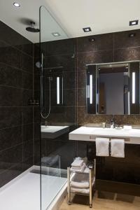 bagno con doccia, lavandino e specchio di AC Hotel Cincinnati at Liberty Center a West Chester