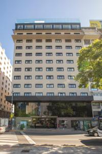 een groot gebouw met een loopbrug ervoor bij El Misti Coliving Obelisco in Buenos Aires