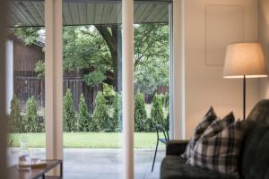 ein Wohnzimmer mit einer Glasschiebetür und Blick auf einen Hof in der Unterkunft Astor Apartments in Olang