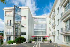 een uitzicht op een wit gebouw met rode parasols bij Best Western Hôtel Journel Antibes Juan-les-Pins in Antibes