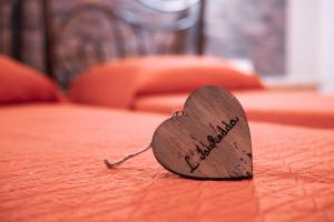 un corazón de madera en la parte superior de una cama en Mare Sole, en San Teodoro