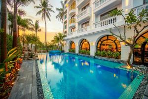 basen przed budynkiem z palmami w obiekcie Grand Sunrise Palace Hoi An w Hoi An