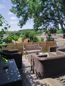 een patio met tafels en stoelen en een hek bij L'île d'Amélie in Ciney