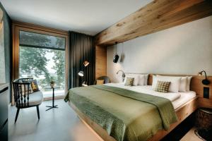 um quarto com uma cama grande e uma janela em Luisenhöhe - Gesundheitsresort Schwarzwald em Horben