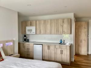 a kitchen with wooden cabinets and a bed in a room at Lunenburg Arms Hotel in Lunenburg