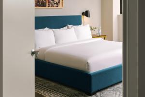 um quarto com uma cama grande e uma cabeceira azul em Sonder Georgetown C&O em Washington