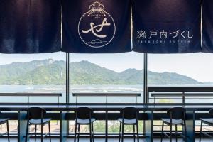 un groupe de chaises assises devant une fenêtre dans l'établissement Aki Grand Hotel & Spa, à Miyajima