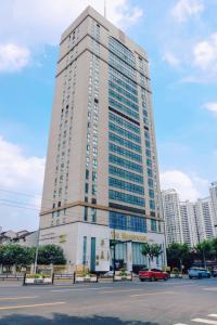 un grand bâtiment blanc avec des voitures garées devant lui dans l'établissement Magnificent International Hotel, à Shanghai