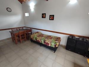 1 dormitorio con cama, mesa y escritorio en TATOVGB, en Villa General Belgrano