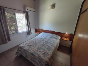 1 dormitorio con cama y ventana en TATOVGB, en Villa General Belgrano