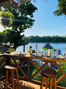 una mesa de madera con sillas y vistas al río en Pousada Do Porto, en Barreirinhas