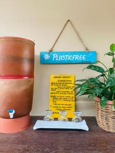 una mesa con una planta y un cartel en la pared en Pousada Do Porto, en Barreirinhas