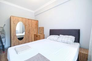 a bedroom with a white bed and a mirror at Palmiye Apart Hotel in Antalya