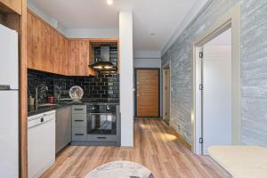 a kitchen with white cabinets and a brick wall at Palmiye Apart Hotel in Antalya