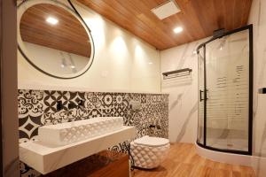 a bathroom with a shower and a sink and a mirror at Le Villagio Resort & Domes in Sultan Bathery