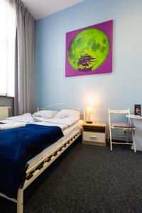 um quarto com uma cama e um quadro na parede em Moon Hostel Gdańsk em Gdańsk