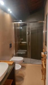 bagno con 2 servizi igienici e doccia in vetro di La casetta Guest House Oristano a Oristano