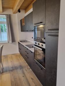 a kitchen with stainless steel appliances and wooden floors at Appartamento Vale e Schena Cortina D'Ampezzo in San Vito di Cadore