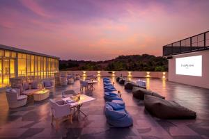 The Westin Goa, Anjuna في أنجونا: فناء على السطح مع كنب وطاولات وشاشة